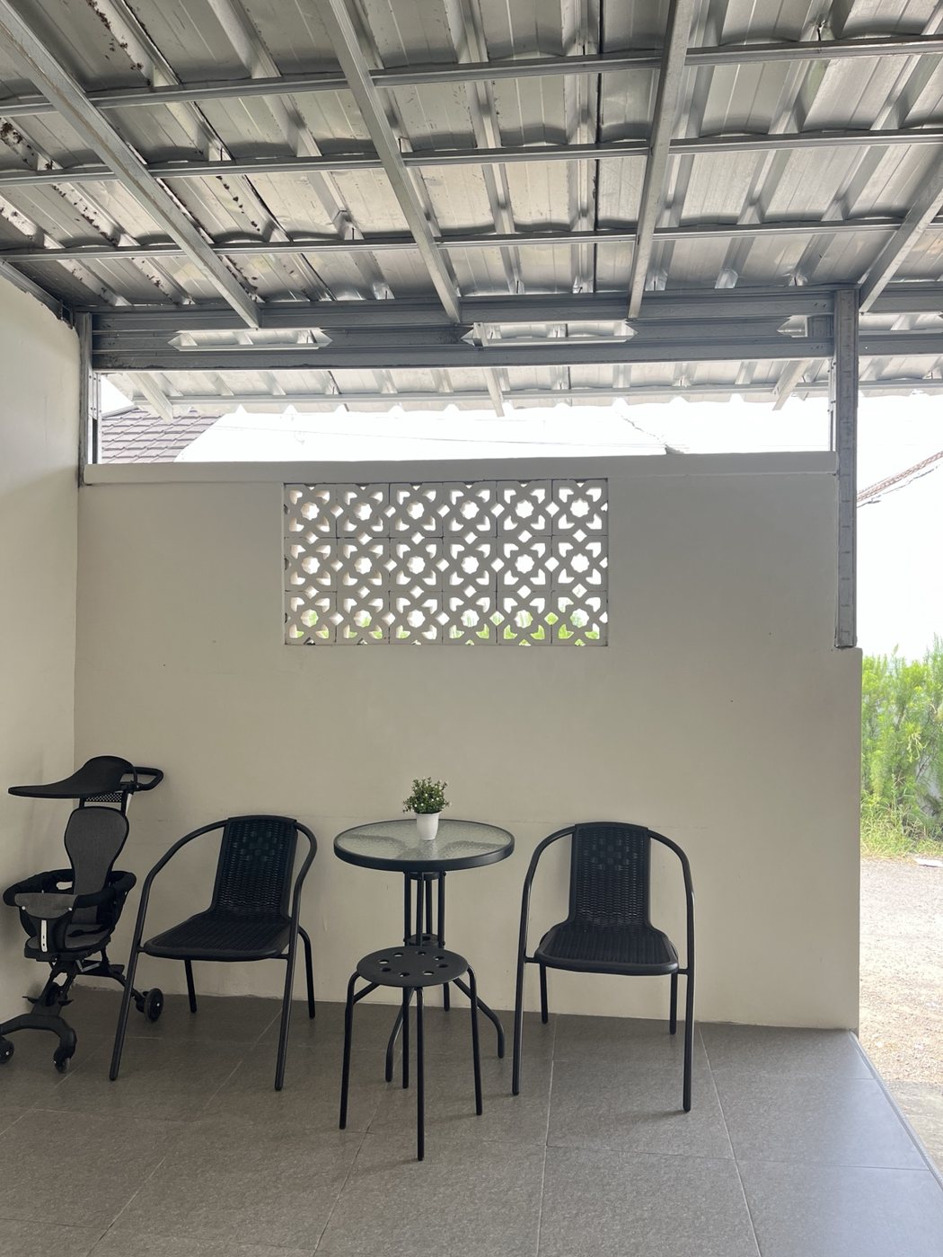 Teras rumah dengan kanopi besi dan roster